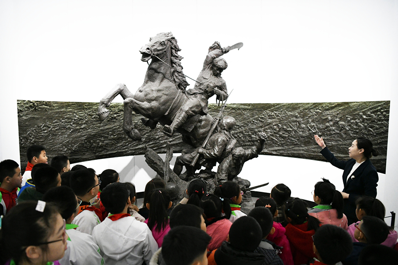 2019年4月4日，在東北烈士紀(jì)念館，學(xué)生們?cè)诼犞v解員講解。